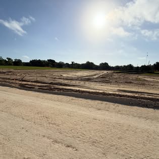 Freshly graded pad on a cleared Florida lot at sunrise