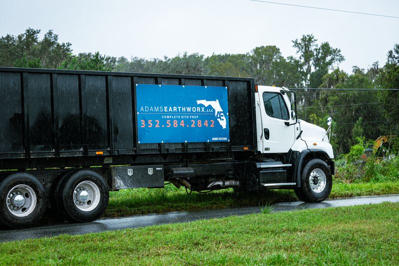 Adams Earthworx dump truck with the company logo on the side