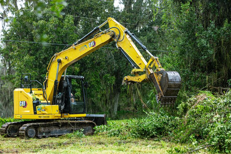 Sam Adams pulling brush and saplings with the CAT excavator