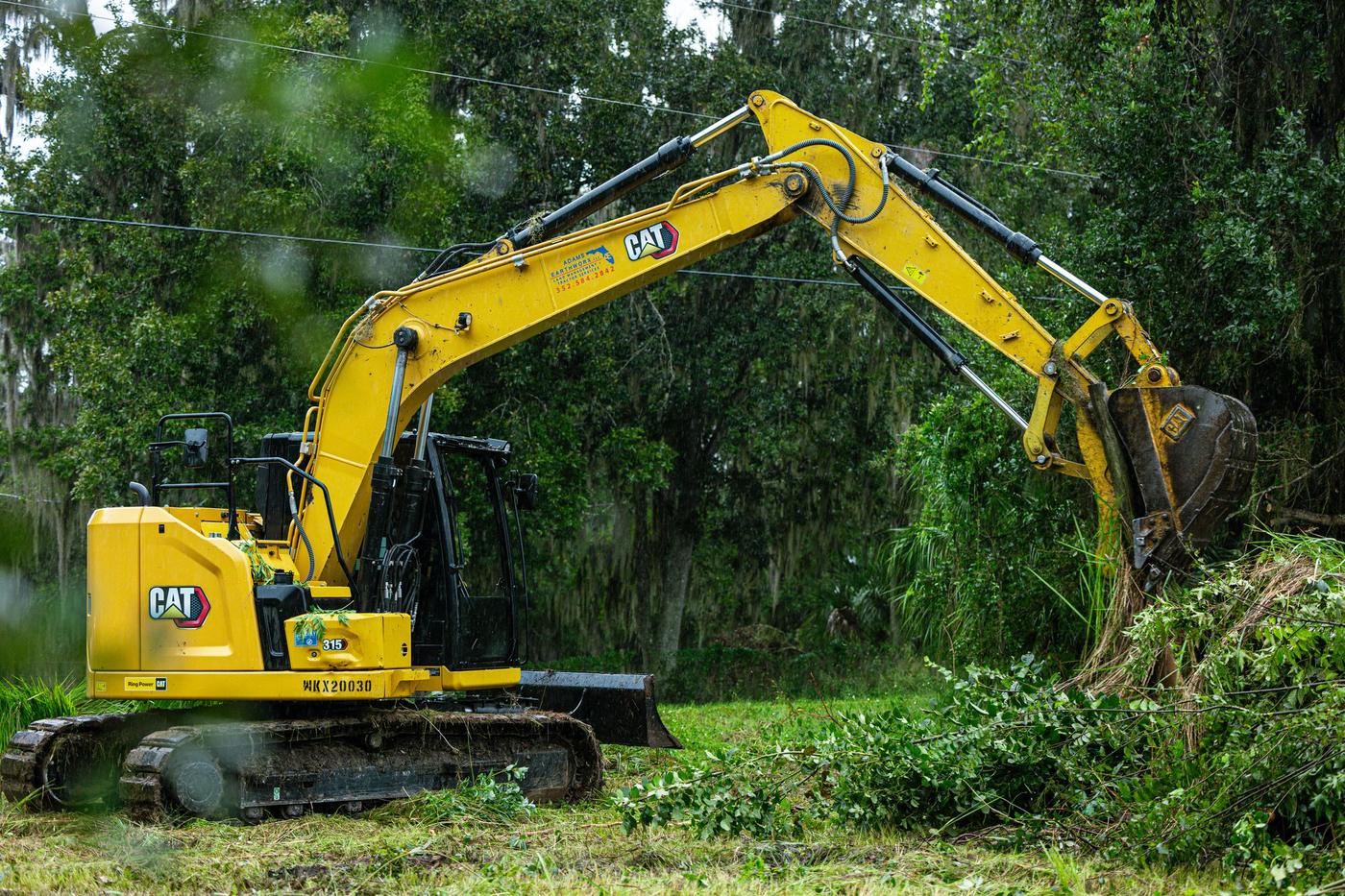 CAT excavator loading a bucket of brush
