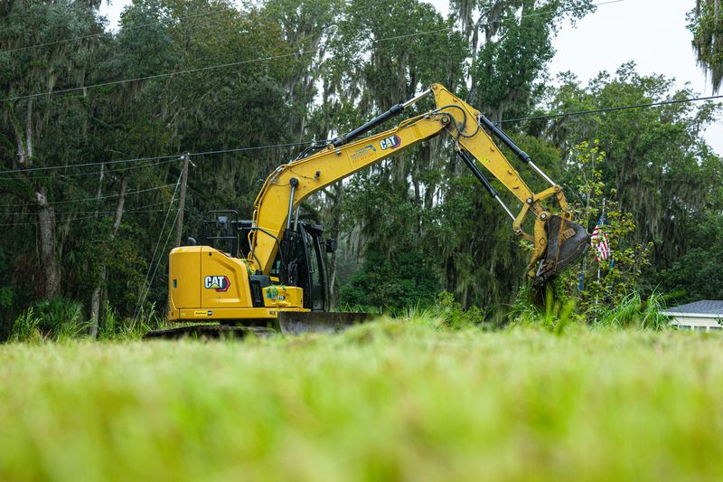 CAT excavator working the edge of a cleared field