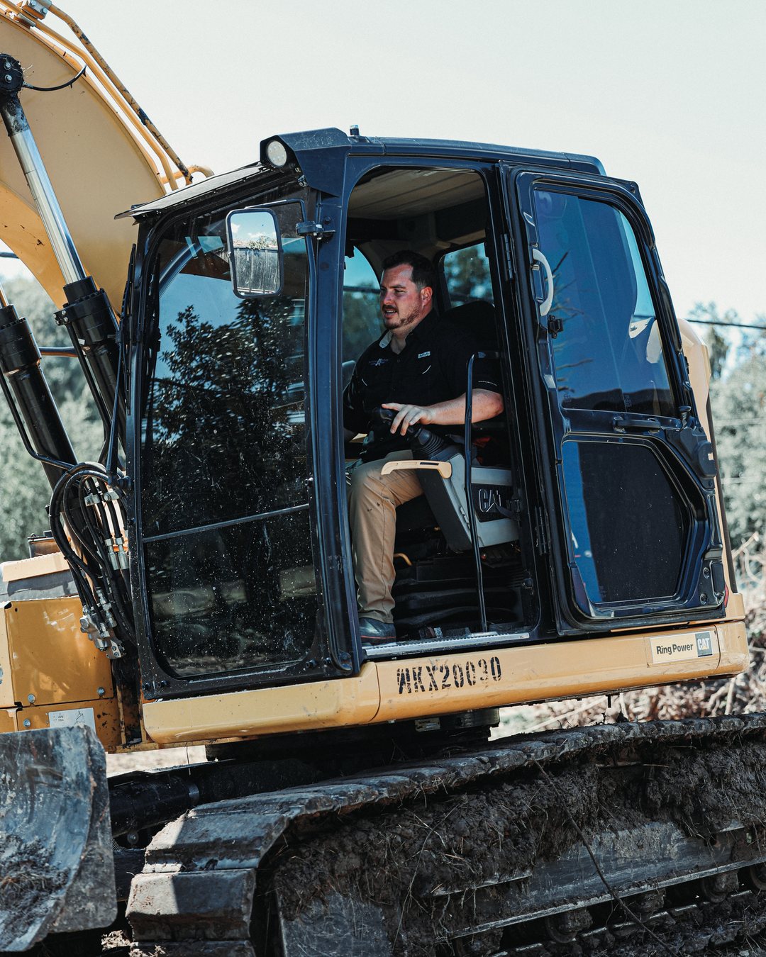 Sam Adams, owner and operator of Adams Earthworx, at the controls of his CAT excavator